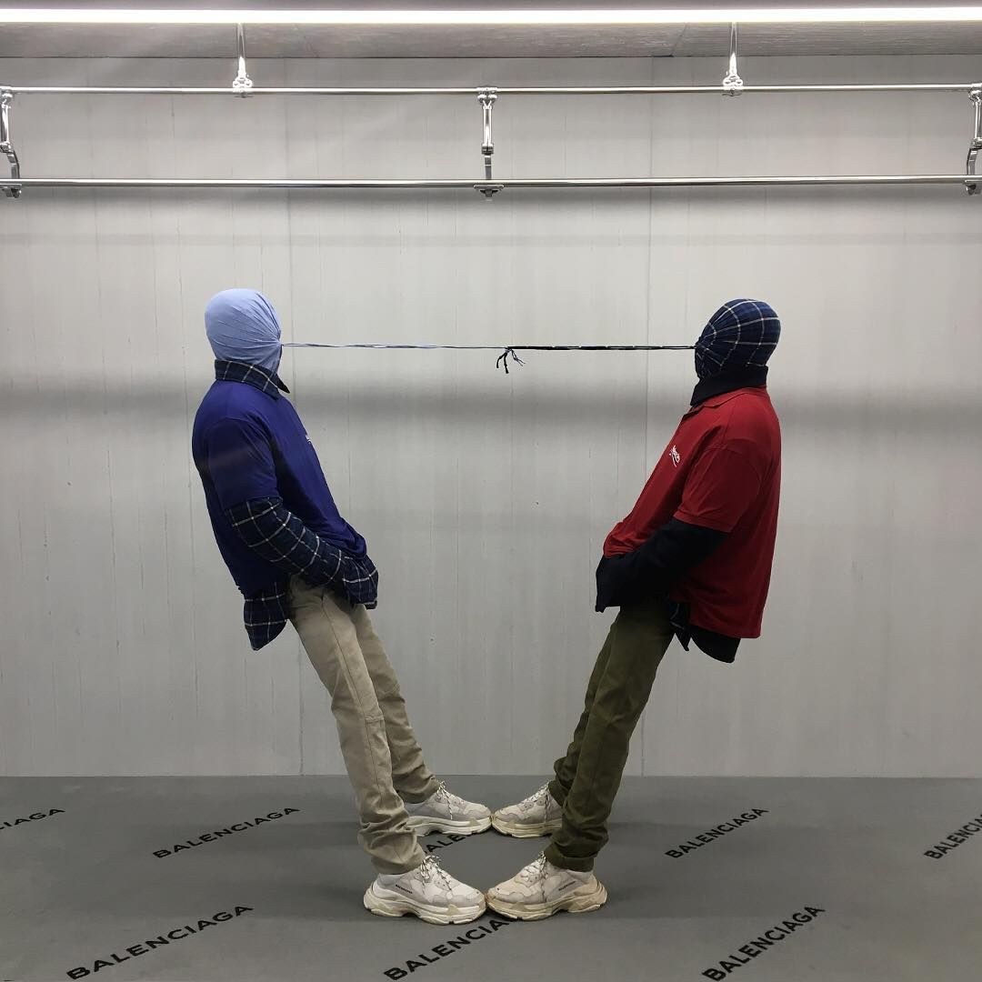 Two hooded figures tethered head to head, Balenciaga, New York