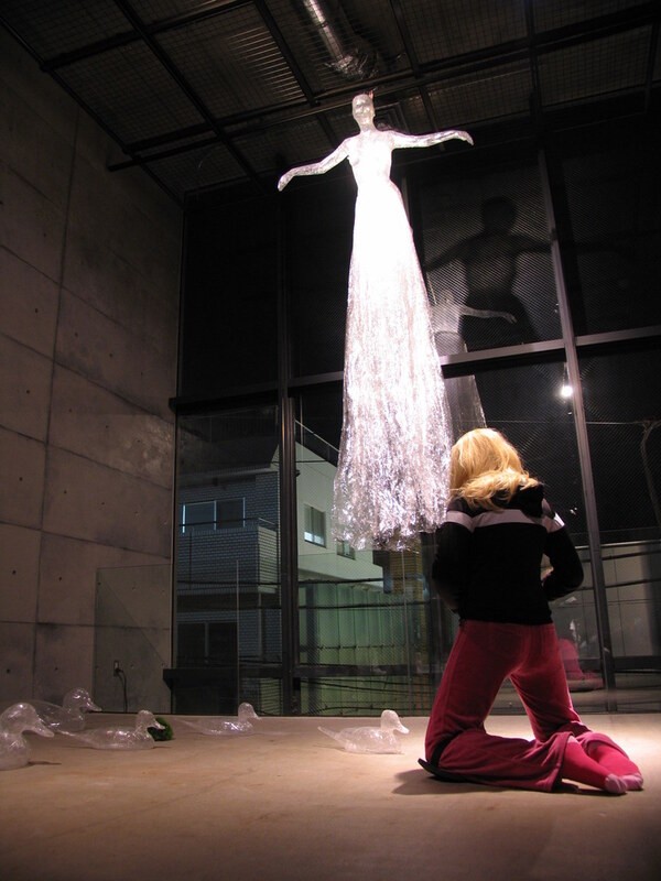 Hanging white figure and kneeling figure