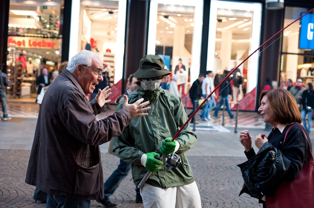 Fisherman figure with passers-by