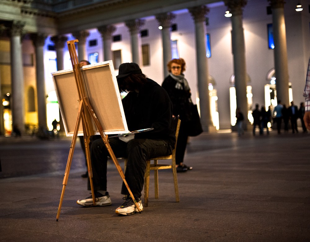 Street painter figure at an easel at night